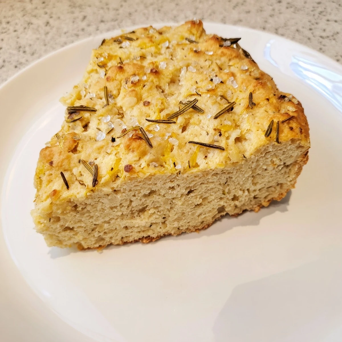 Freshly baked Yeast-Free Garlic and Rosemary Bannock Bread, with visible herbs and a crispy, warm crust.