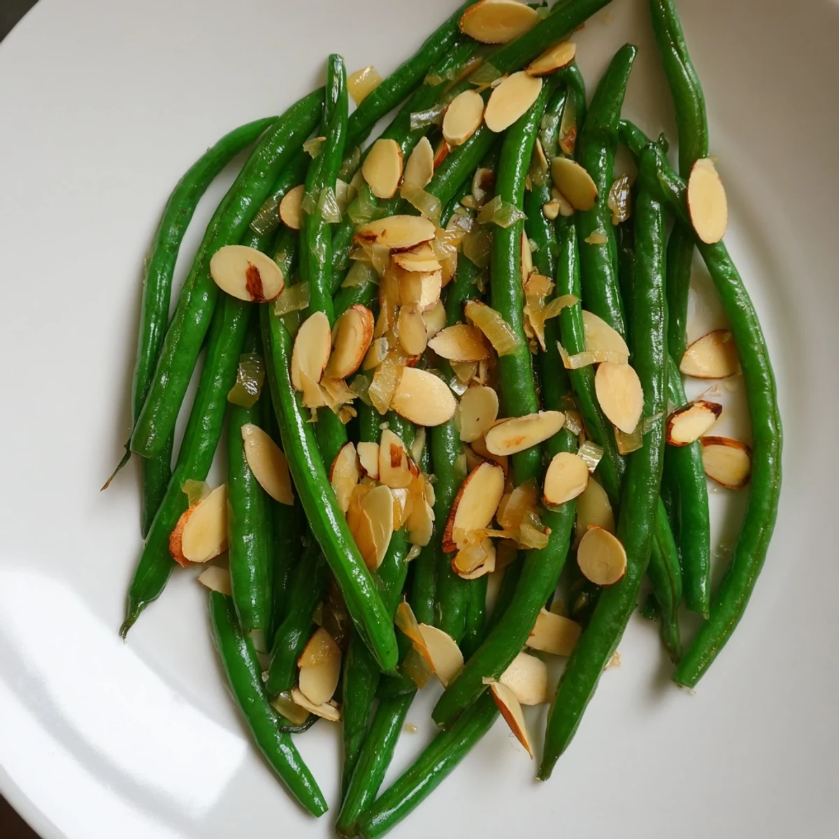 Bright green sautéed green beans with garlic and almonds, a crunchy side dish, ready to serve.