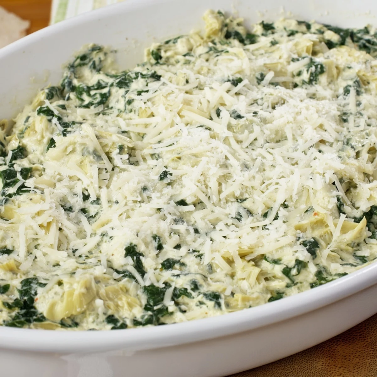 A bubbly, cheesy Warm Spinach and Artichoke Dip, perfect with crispy baguette slices for dipping.