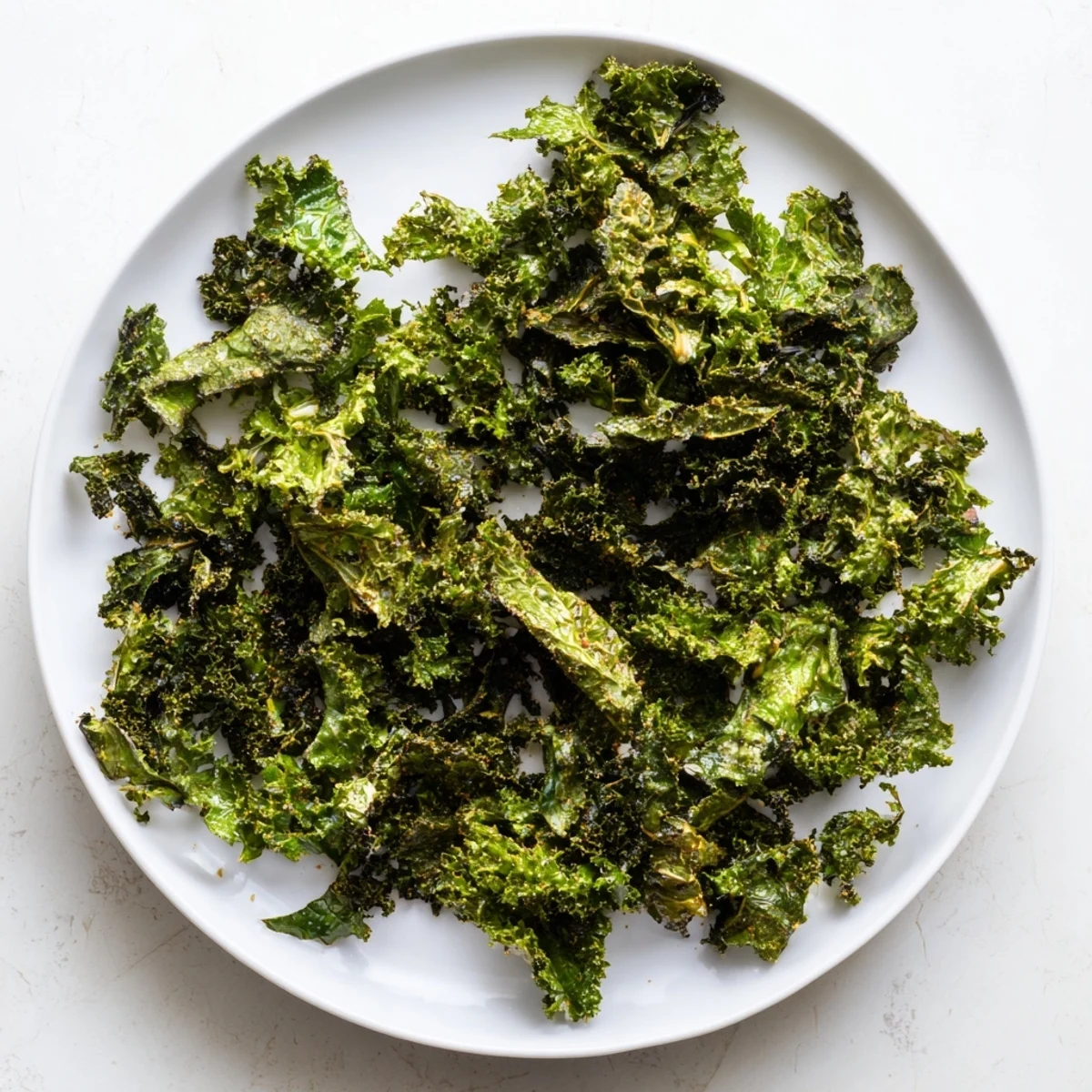 Crispy, golden-brown kale chips baked in the oven, a perfect healthy and salty snack.