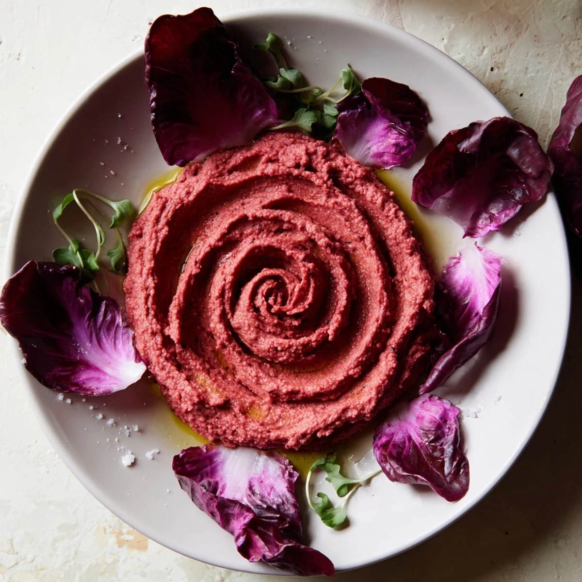 Artistic presentation of The Velvet Rose: Earthy beet hummus roses ready to be enjoyed with fresh, bitter radicchio.