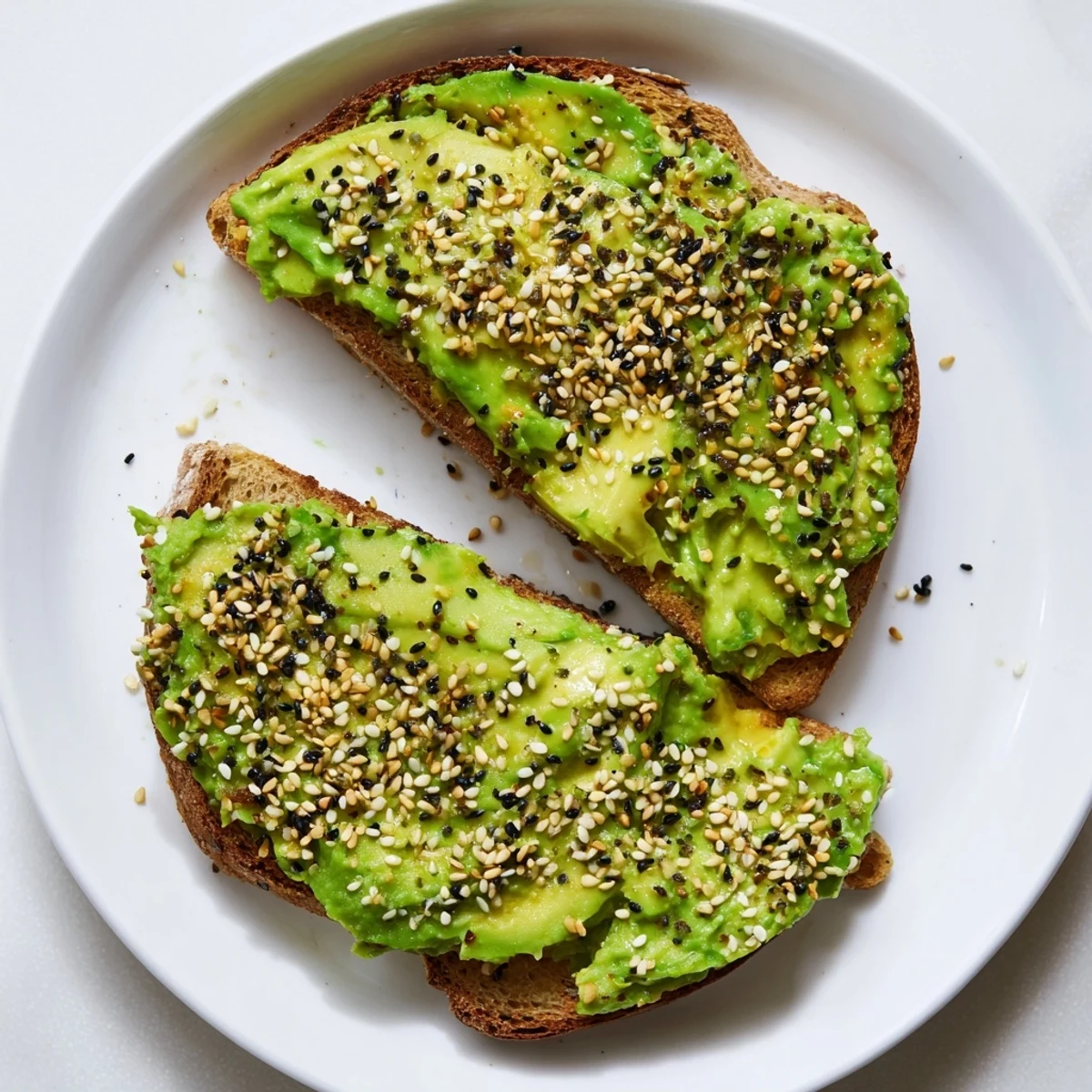 Golden, toasted bread piled high with creamy avocado toast with everything, sprinkled perfectly.
