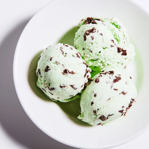 A scoop of refreshing Mint Chocolate Chip Ice Cream, a cool summer dessert delight.