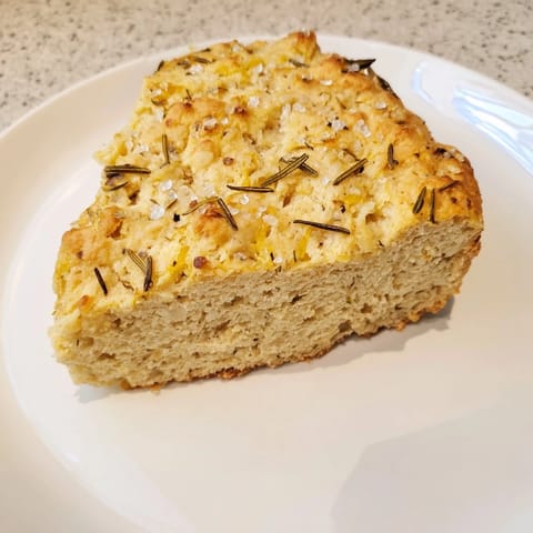 Freshly baked Yeast-Free Garlic and Rosemary Bannock Bread, with visible herbs and a crispy, warm crust.