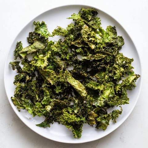 Crispy, golden-brown kale chips baked in the oven, a perfect healthy and salty snack.