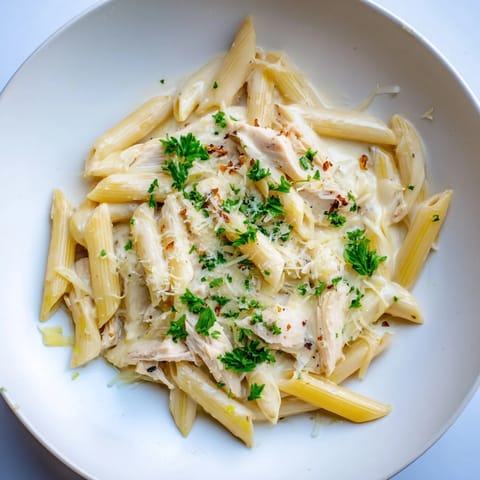 Golden penne pasta coated in rich, creamy sauce featuring tender chicken in this Tina's pasta.