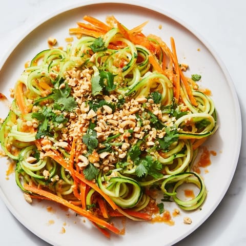 Freshly tossed Spicy Cucumber Noodle Bowl: a vegetarian delight with crunchy carrots and sesame seeds.
