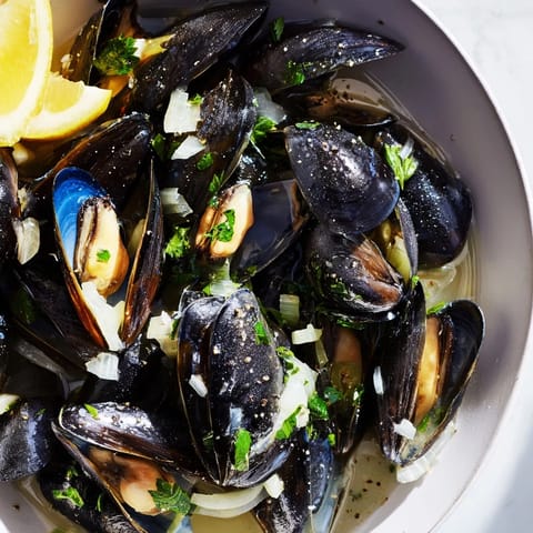 Picture a bowl overflowing with savory Belgian Moules Marinière, ready to savor and enjoy with crusty bread.
