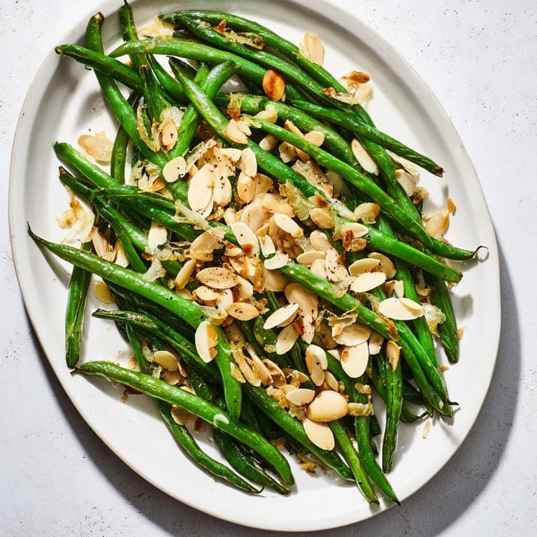 Close-up of golden sautéed green beans with garlic and almonds, a flavorful and easy recipe.