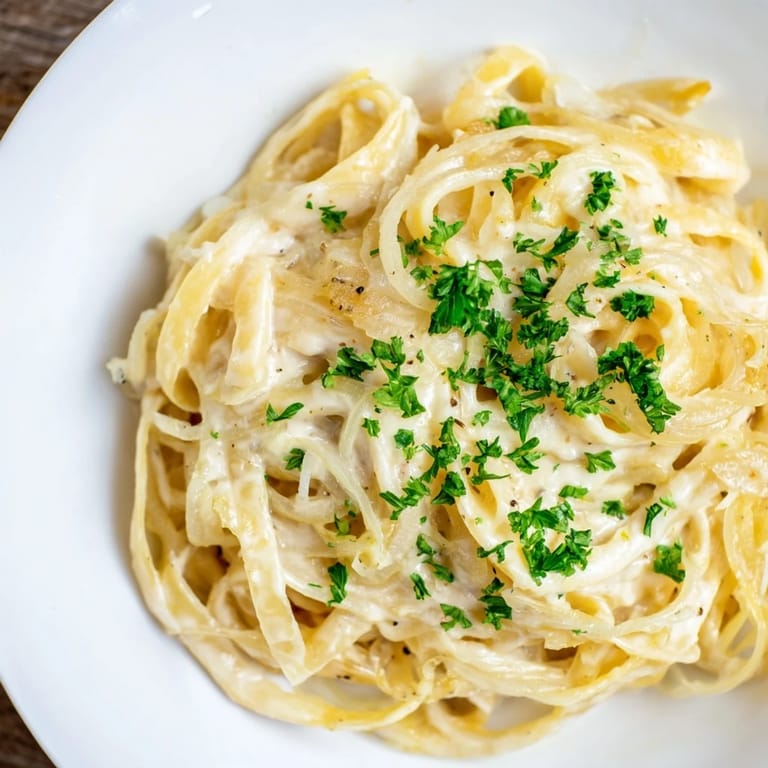 Golden, caramelized onions topping a creamy one-pot French onion pasta, ready for a delicious dinner.
