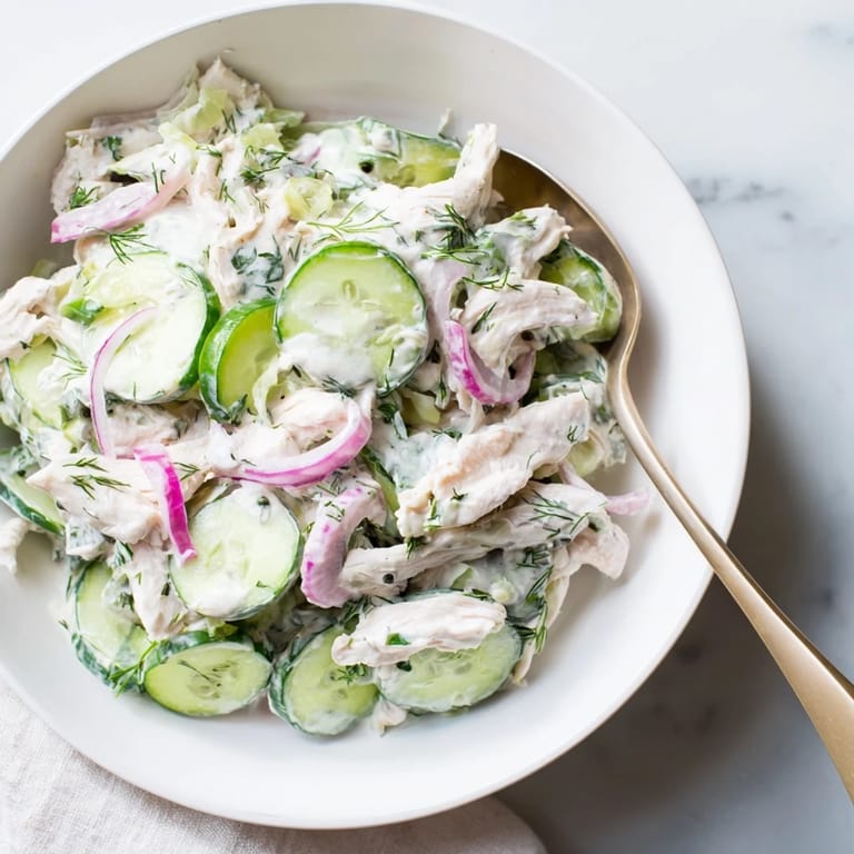Bright, fresh ingredients for creamy cucumber chicken salad laid out on a wooden cutting board, ready for quick assembly.  