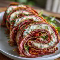 Italian sub pinwheel wraps showcase colorful layers of deli meats, cheeses, and vegetables rolled in soft tortillas.  
